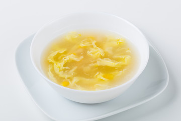 soup in the white bowl with mais, eggs and chicken