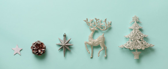 Silver Christmas decoration - deer, fir-tree, stars, cone on blue background with copy space. Festive card for winter event, party. Top view, flat lay. New year concept in minimal style. Banner