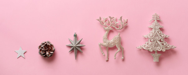 Silver Christmas decoration - deer, fir-tree, stars, cone on pink background with copy space. Festive card for winter event, party. Top view, flat lay. New year concept in minimal style. Banner