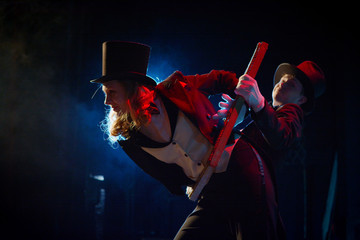 young actor and actress in tuxedos and hats dancing