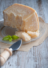 Parmesan cheese in the foreground next to utensil.