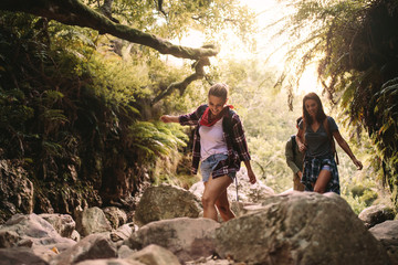 Friends walking through rocks on mountain trail