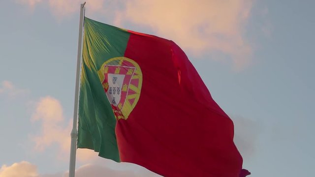 Portuguese flag waving on evening sky close-up