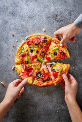 Hands taking fresh pizza slices. Pizza party. Top view. Copy space.