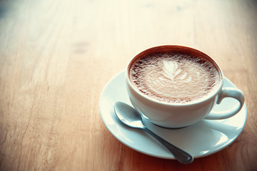 Latte coffee in glass placed on wooden floor.