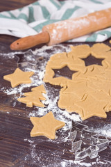 Gingerbread homemade cookies preparation for Christmas fest. Wooden table flat lay composition with rolling pin.
