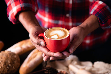 Barista's hands are delivering coffee to customers.