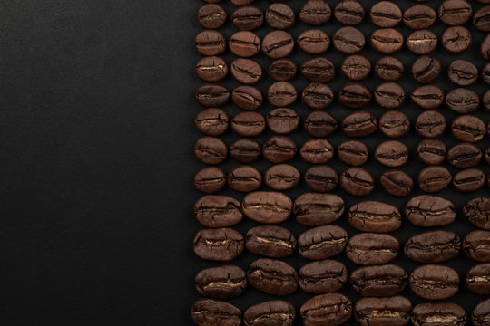 Roasted coffee beans on black background. Top view with space for your text