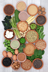 Health food high in protein with tofu, fresh vegetables, legumes, grains, dairy, supplement powders, seeds and nuts. Super foods high in dietary fibre, vitamins and antioxidants. Top view.