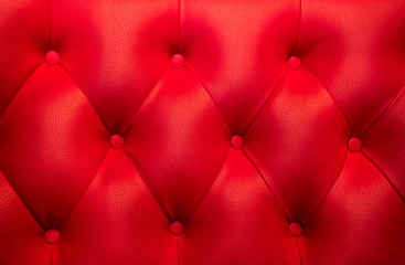 Red leather upholstery with red buttons background.