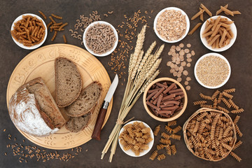 Fototapeta na wymiar High fibre natural health food with whole wheat pasta, whole grain rye bread, oatmeal, oats, bran flakes and wheat sheath on lokta paper background. 