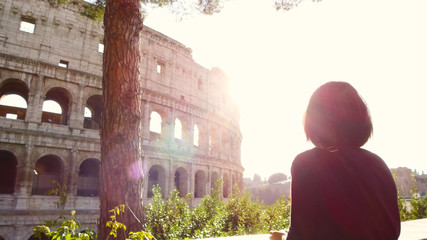 tourist woman looks enchanted the majestic Colosseum of Rome