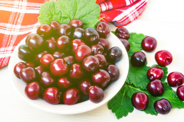 Fresh ripe sweet cherry in a plate on a light table