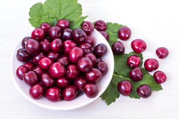 Fresh ripe sweet cherry in a plate on a light table
