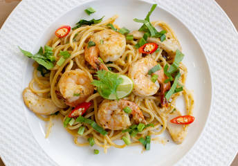 top view of delicious spaghetti seafood with shrimps, tomatoes, basil and cheese - italian food style