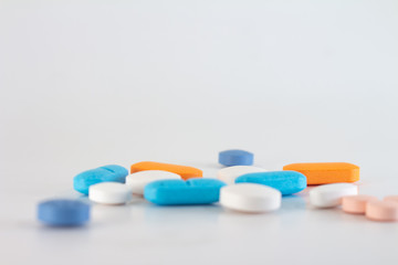 Numerous colored pills on a neutral background.