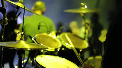 Concert rock band performing on stage. Drummer plays drums. Slow motion