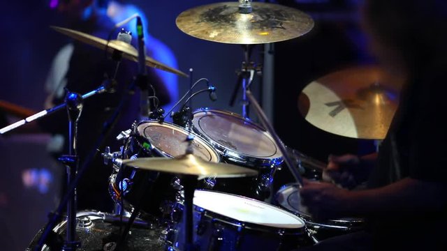 Concert rock band performing on stage. Drummer plays drums. Slow motion - Powered by Adobe