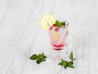 Refreshing summer cocktail with lemon, raspberry and mint a light table