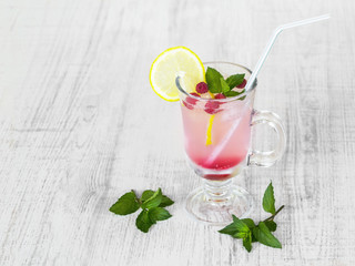 Refreshing summer cocktail with lemon, raspberry and mint a light table