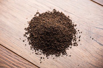 Black Tea Powder or dry dust with or without green leaf and served hot chai in a cup