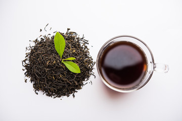 Black Tea Powder or dry dust with or without green leaf and served hot chai in a cup - obrazy, fototapety, plakaty