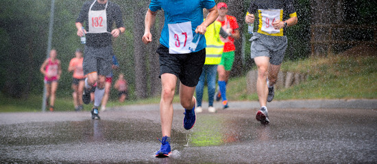 runners running under rain drops city marathon