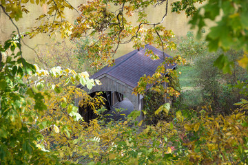 Fototapeta na wymiar overhead view of old wooden covered bridge in autumn foliage and river