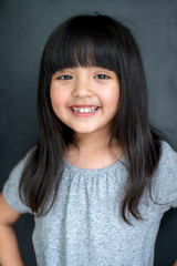 happiness black hair asian big eye girl portrait photo shoot with casual dress with fun on black screen background