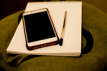 mobile phone, notebook and pen