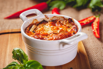 Celery root gratin with cheese and mushrooms on wooden board. Close up