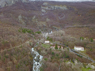 Fototapeta na wymiar Hubelj Spring (Izvir Hubelj) below Trnovski gozd in Ajdovščina, Slovenia, is a big karst spring below rock wall. During high waters, there are a number of waterfalls emerging from a rock wall. 