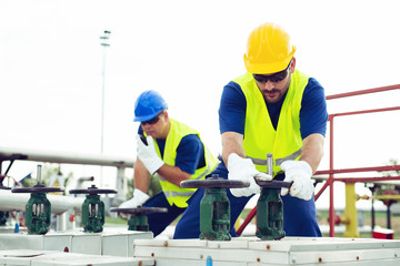 Oil worker closes the valve on the oil pipeline