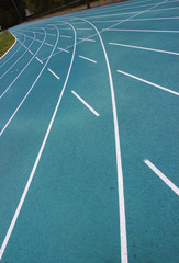 running racetrack with white lines on blue ground