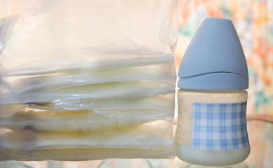 frozen breast milk in storage bags and baby bottle