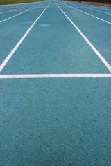 running racetrack with white lines on blue ground