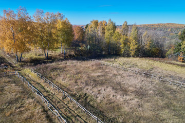 High-altitude shooting of the autumn glade with a wooden fence