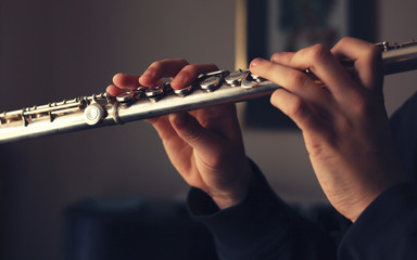 the hands of the flutist playing the flute © Jane
