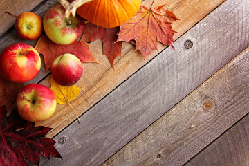 Rustic Autumn Wooden Background Framed by Apples and Fall Maple Leaves