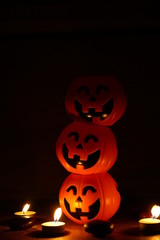Three pumpkins smile and candle decorate on wood background for halloween night