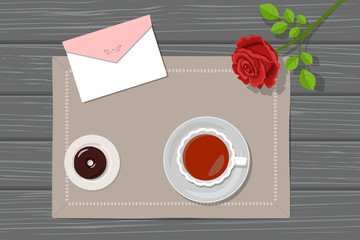 Tea, donut, envelope and rose on linen napkin