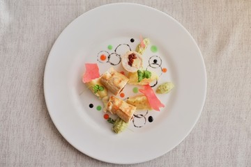 Pancakes with sliced ham and cheese, decorated with salad on a light background. Traditional Russian cuisine top view