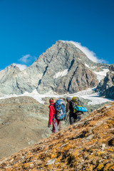 Two mountaineers watching Grossglockner peak in autumn, Austria