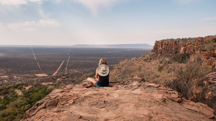 Junge Frau sitzt auf Waterberg, Namibia, Panorama