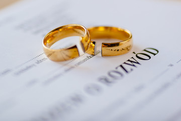 Divorce decree in Polish language and two broken wedding rings - obrazy, fototapety, plakaty