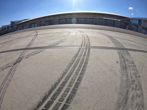 Wheel marks on concrete and on the pavement after drifting on a sunny day