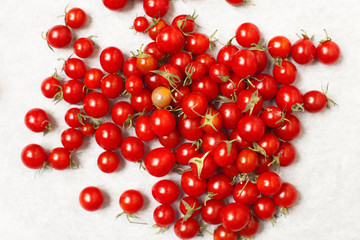 Overhead close up image of mini tomatoes on a white background