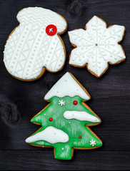 Christmas background with tasty homemade gingerbread cookies with icing on wooden table, top view, flat lay. Christmas tree, snowflake, mitten. Christmas food, copy space