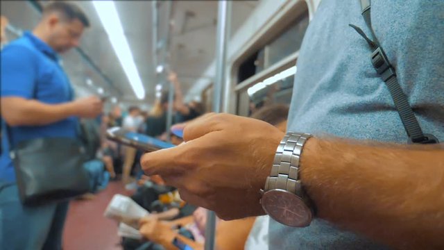 Casual man reading from mobile phone smartphone screen while looks the navigator traveling on metro in lifestyle the subway. slow motion video. Wireless internet on public transport concept. man in