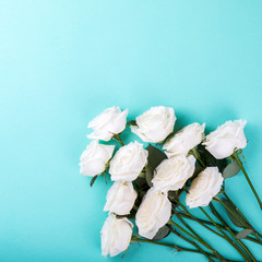 Fototapeta premium White Natural Roses Bouquet on the Colored Naked Background Holiday Concept Top View Copy space for Text Flat Lay Toned image